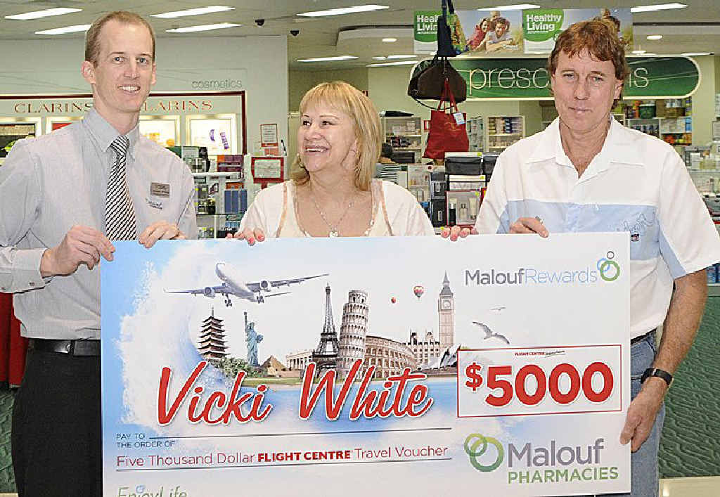 The Ridge Malouf Pharmacies manager Michael Spargo (left) presents Vicki White and Ron White with $5000 worth of travel vouchers.